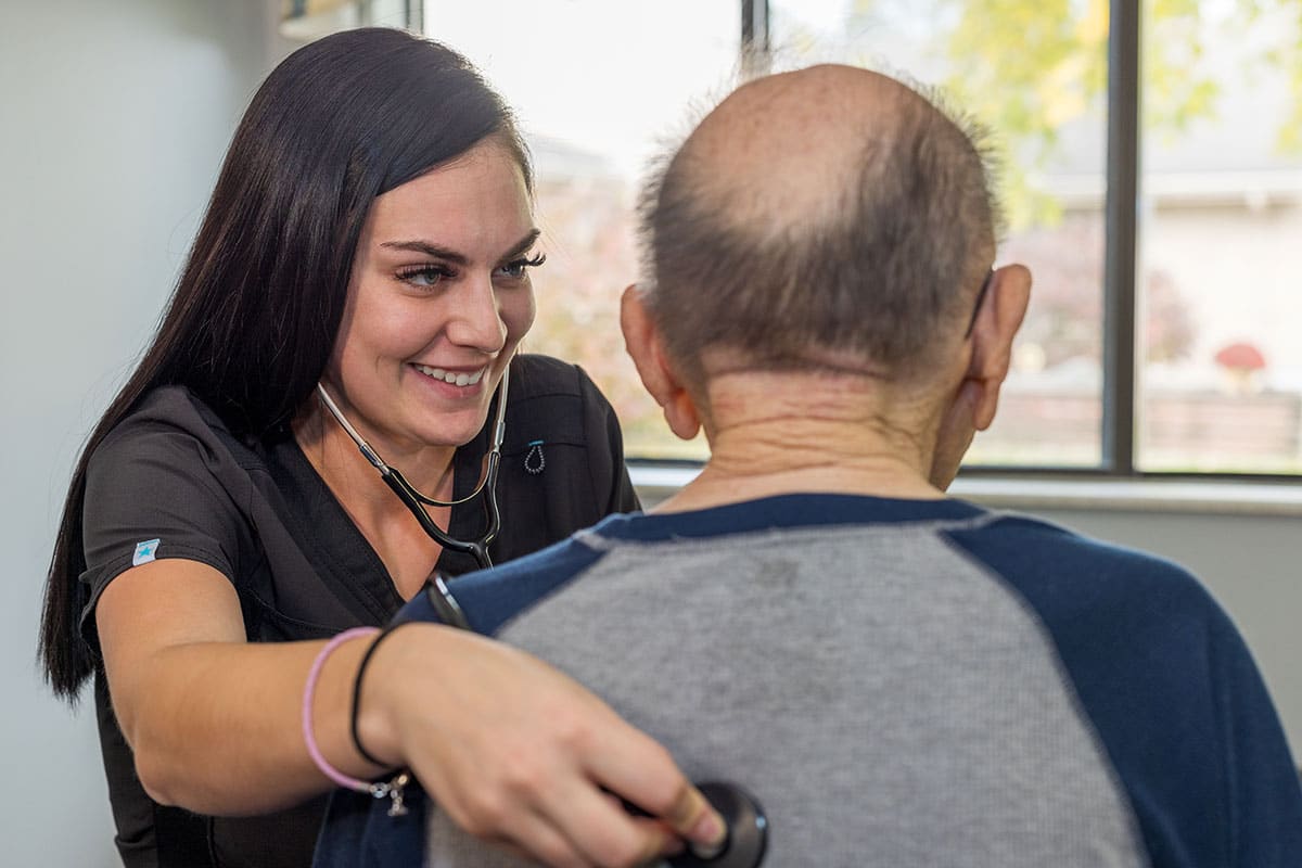 A nurse and an elderly resident at the Willow Knoll facility
